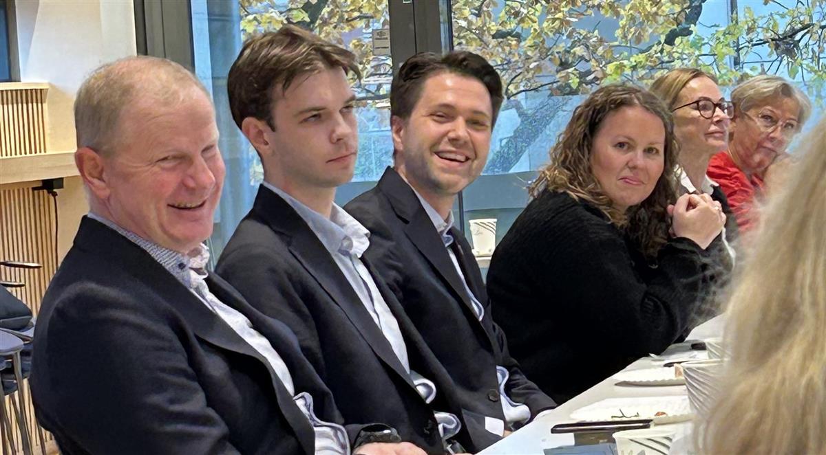 Politikere som sitter ved siden av hverandre ved et bord. - Klikk for stort bilde