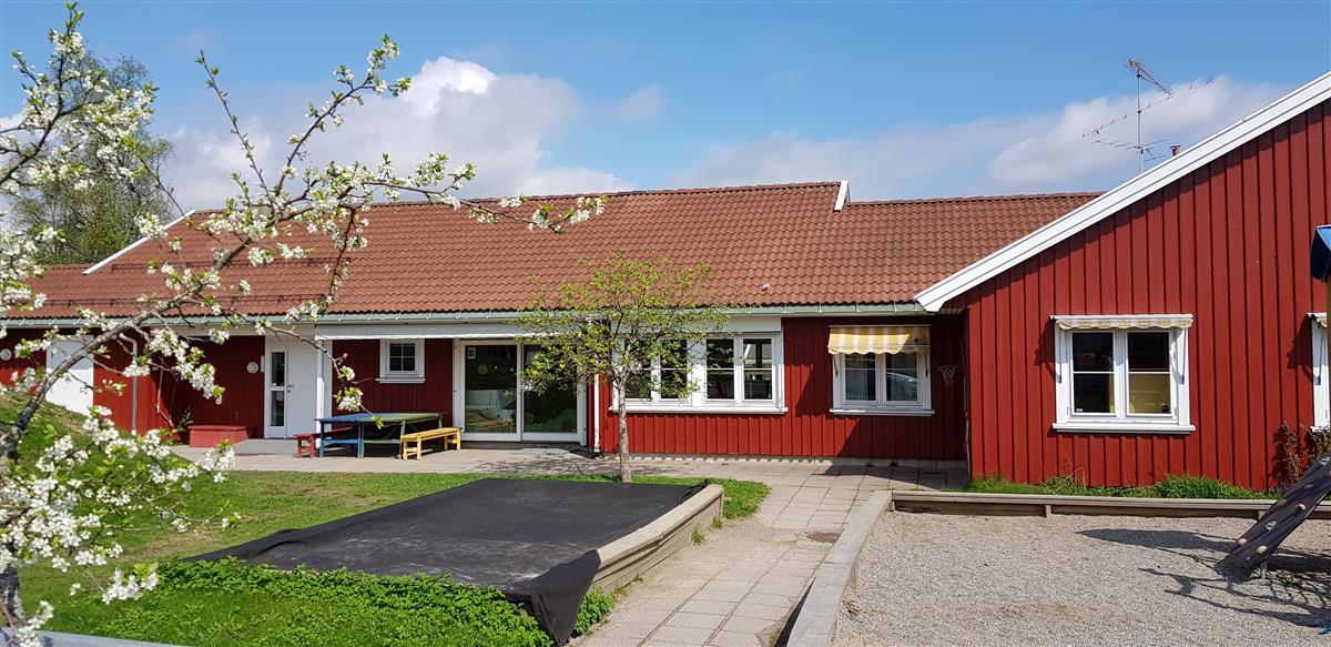 Stort rødt hus med lekeplass foran - Klikk for stort bilde
