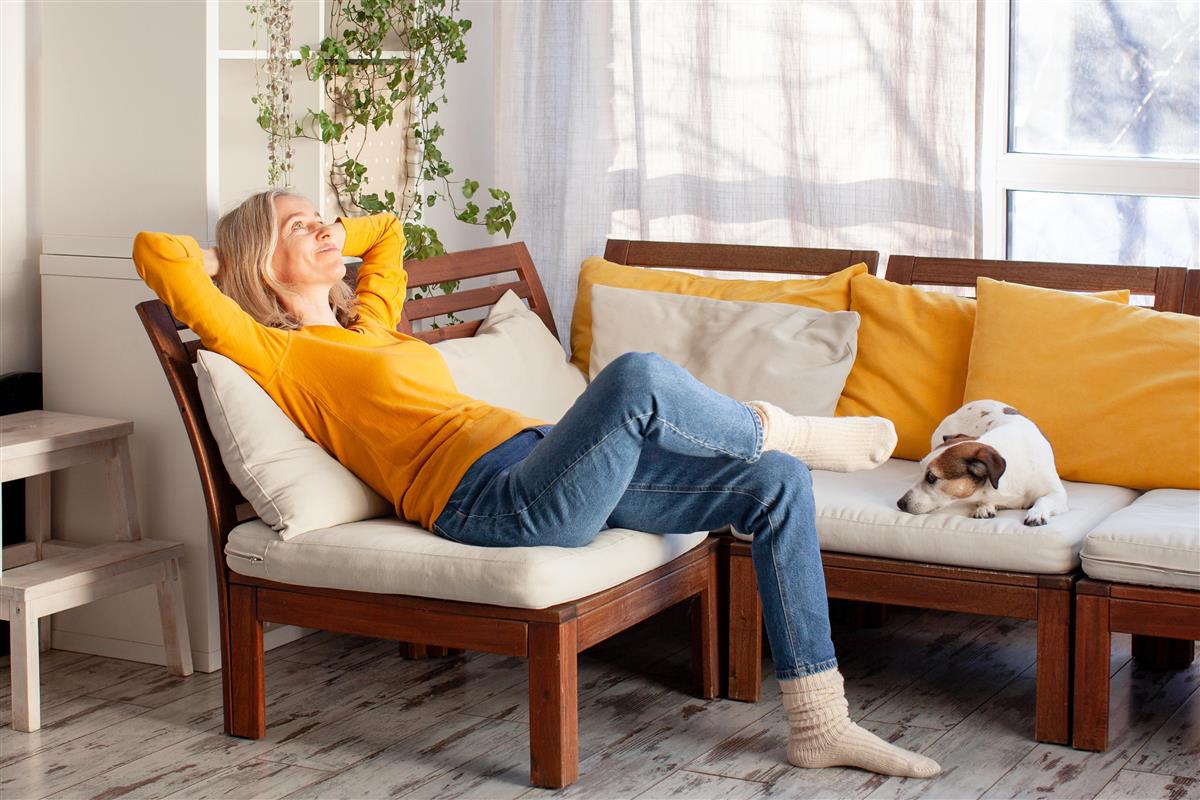 Dame og hund hviler på en sofa - Klikk for stort bilde