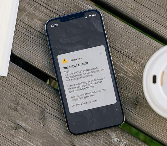 Mobiltelefon med nødvarseltekst - Klikk for stort bilde