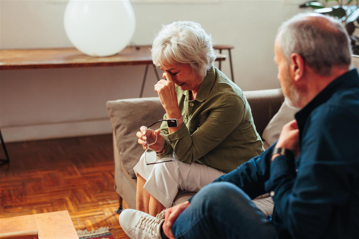 Illustrasjonsbilde av en dame som sitter i sofa og gråter - Klikk for stort bilde
