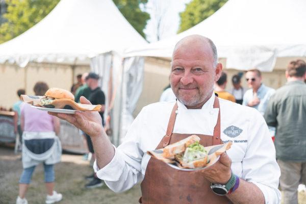 Mann med mattallerkener på festivalområdet. - Klikk for stort bilde