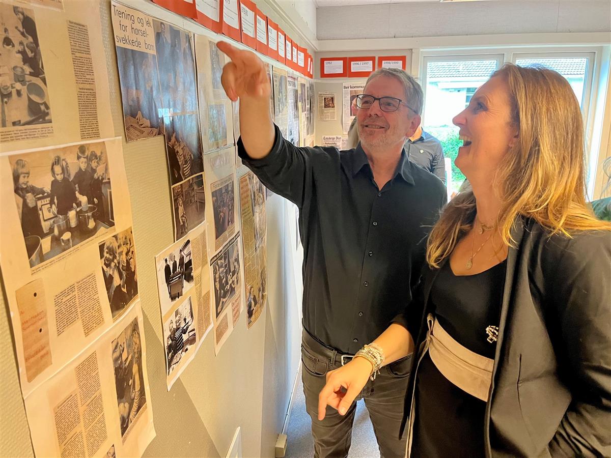 Kommunalsjef Espen Riiser og styrer Cecilie Byholt betrakter utstillingen som viser barnehagens historie.  - Klikk for stort bilde