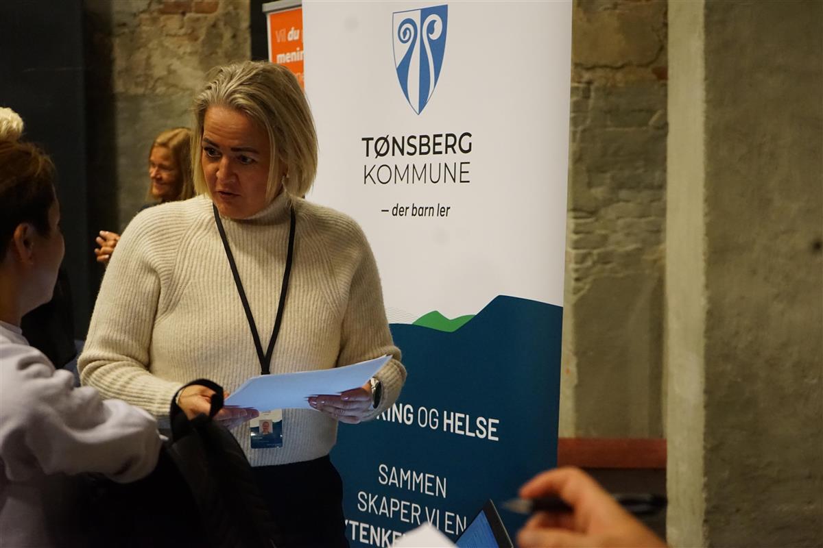 Trude Aksnes ved et rollup med Tønsberg kommunes logo. - Klikk for stort bilde