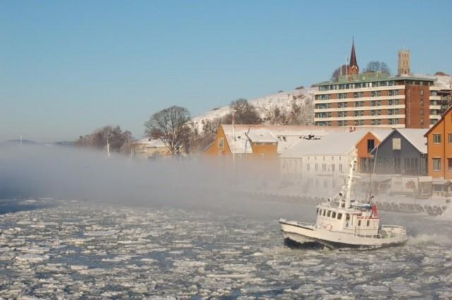 Båt som kjører over is slik at den knekker i Tønsbergfjorden - Klikk for stort bilde